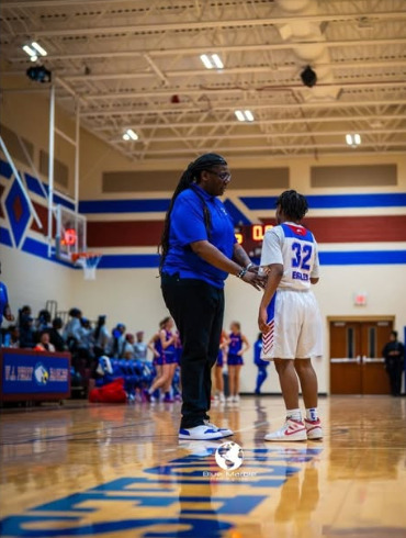 Teresa Geter coaching a young basketball player during game action